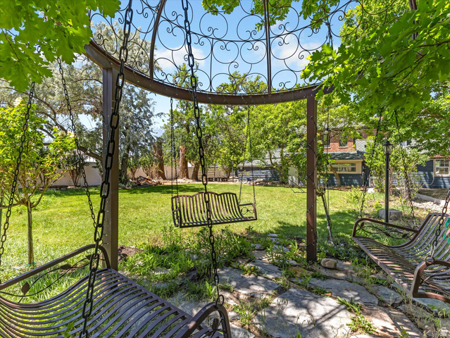 12825 South Fort Street Draper, UT 84020 - Photo 29 of 52 Expansive backyard featuring a central lawn, mature trees, and a decorative metal gazebo with multiple swing seats