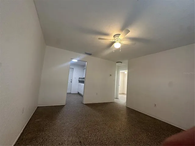 an empty room with a fan and a ceiling fan