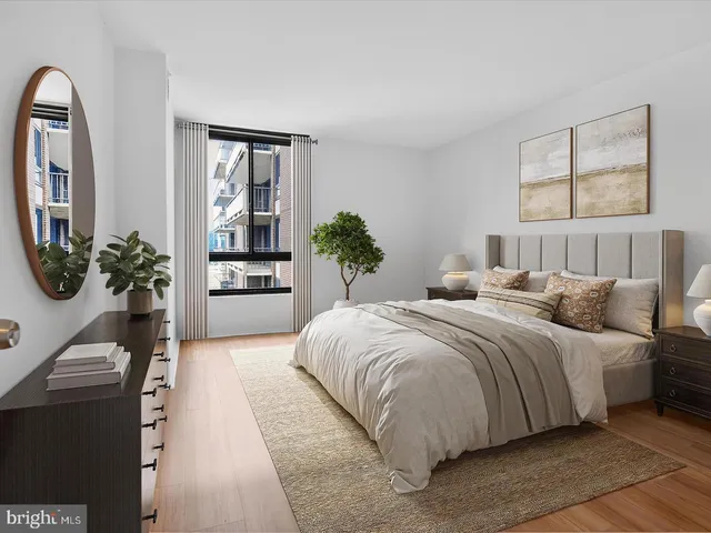 a bedroom with a large bed and a potted plant