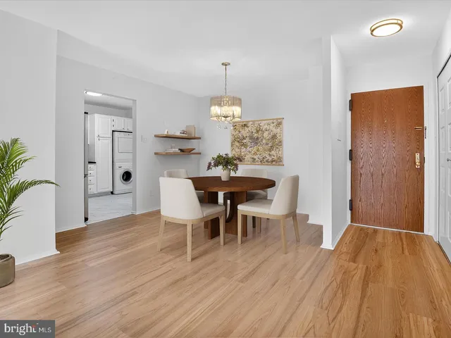a dining room with wooden floor a chandelier a wooden table and chairs