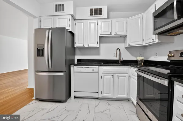 a kitchen with stainless steel appliances granite countertop a refrigerator sink and cabinets