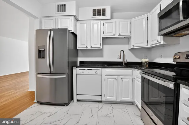 a kitchen with stainless steel appliances granite countertop a refrigerator sink and cabinets