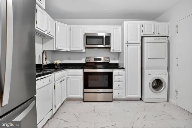 a kitchen with granite countertop a stove top oven and cabinets