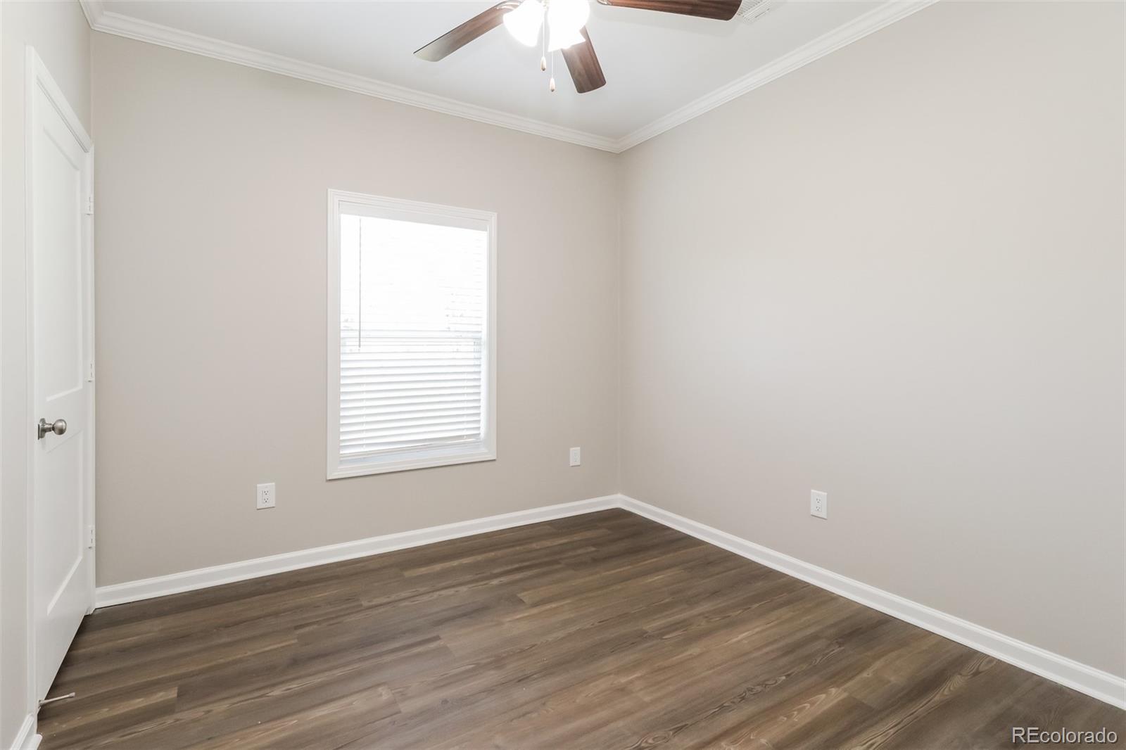 4385 Malta Street Denver, CO 80249 - Photo 11 of 16 an empty room with wooden floor chandelier fan and window