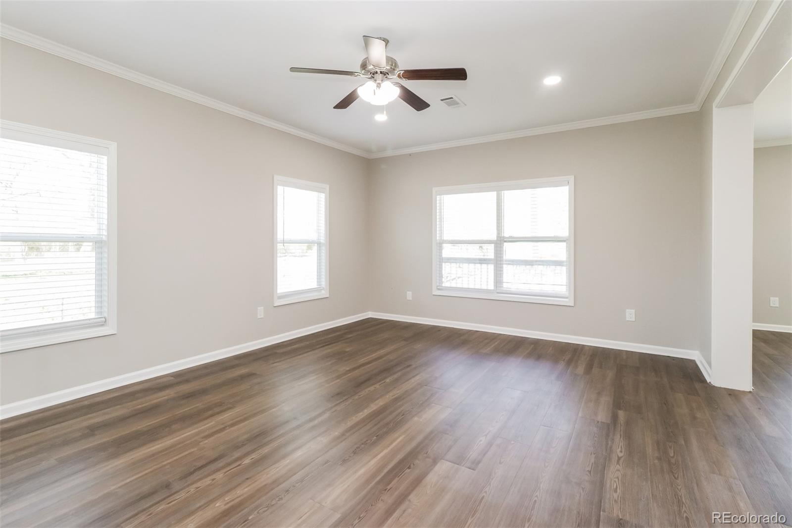 4385 Malta Street Denver, CO 80249 - Photo 4 of 16 an empty room with wooden floor and windows