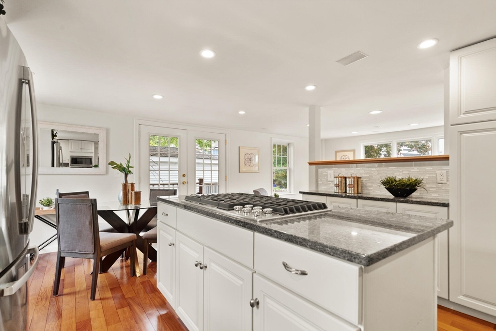 151 Forest Street Malden, MA 02148 - Photo 12 of 33 a kitchen with granite countertop stove a table and chairs in it