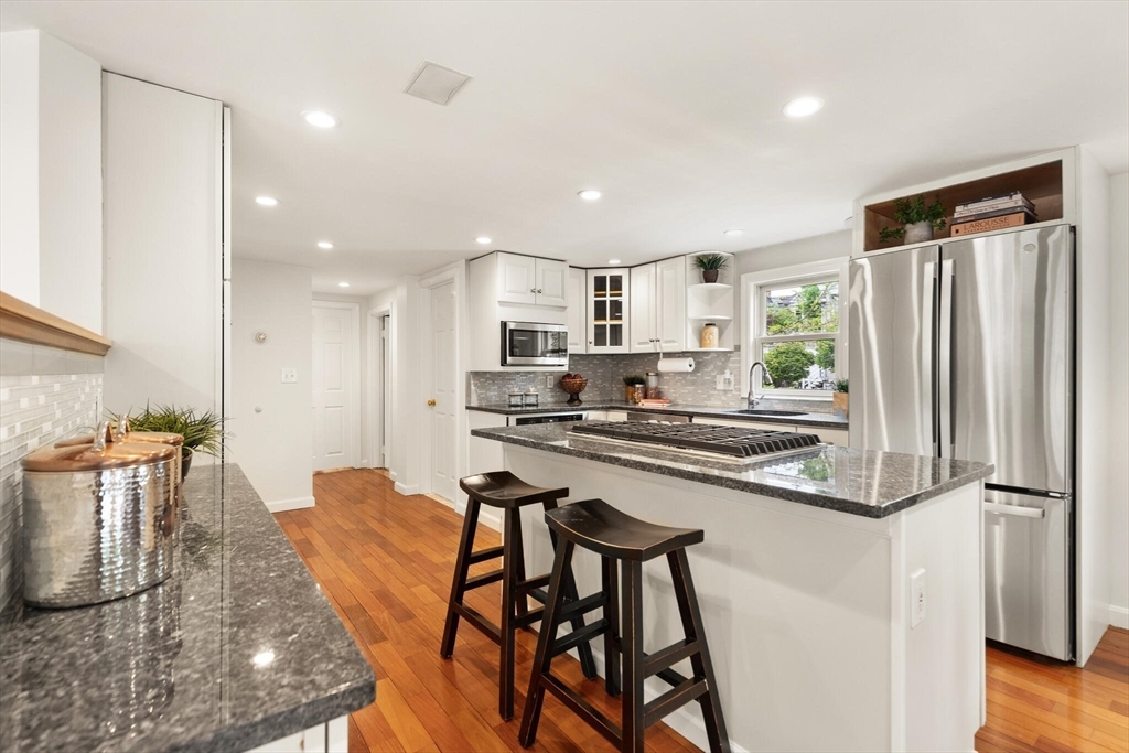 151 Forest Street Malden, MA 02148 - Photo 9 of 33 a kitchen with stainless steel appliances granite countertop a table chairs sink and cabinets