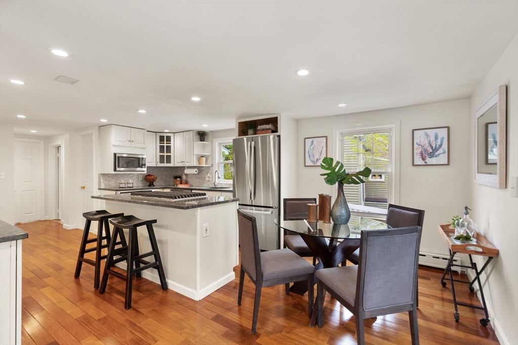 151 Forest Street Malden, MA 02148 - Photo 10 of 33 a kitchen with a table chairs refrigerator and microwave