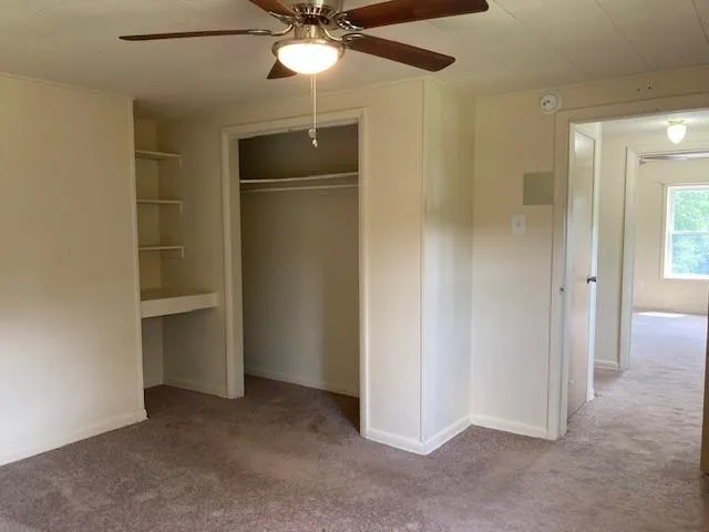 a view of an empty room with a ceiling fan