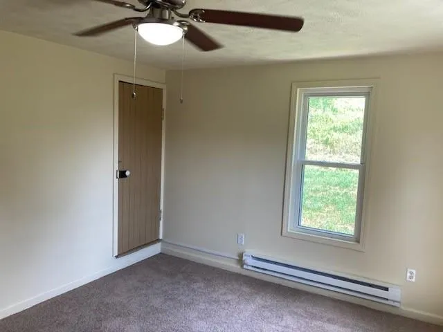 a view of room with window and a ceiling fan