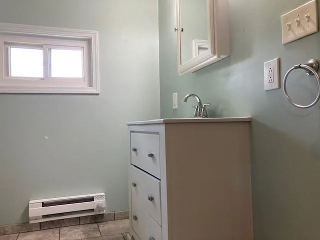 a bathroom with a sink a toilet and a window