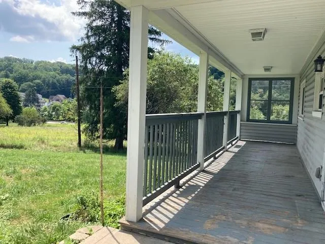 a view of a porch with wooden floor and fence