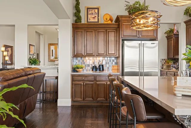 a view of a kitchen with a sink refrigerator and wooden floor