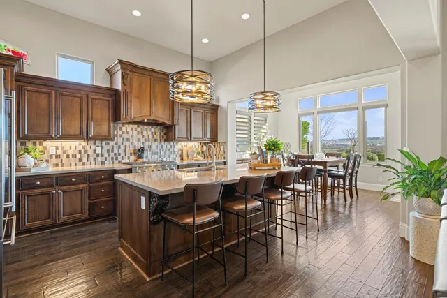 a view of a dining room and livingroom with furniture wooden floor a chandelier