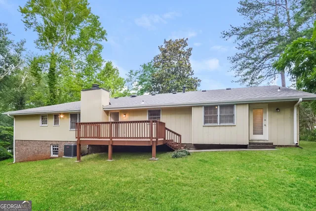 a view of a house with a yard and deck