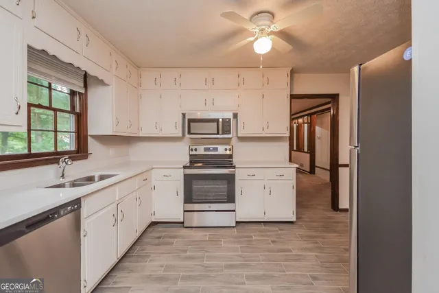a kitchen with white cabinets and stainless steel appliances