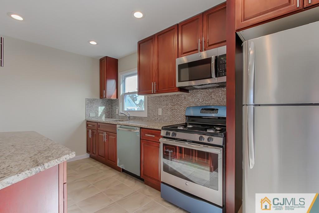 31 Longfield Road New Brunswick, NJ 08901 - Photo 2 of 15 a kitchen with stainless steel appliances granite countertop a stove microwave and refrigerator