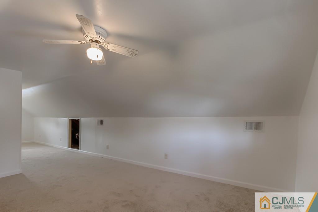 31 Longfield Road New Brunswick, NJ 08901 - Photo 11 of 15 an empty room with a chandelier fan and windows