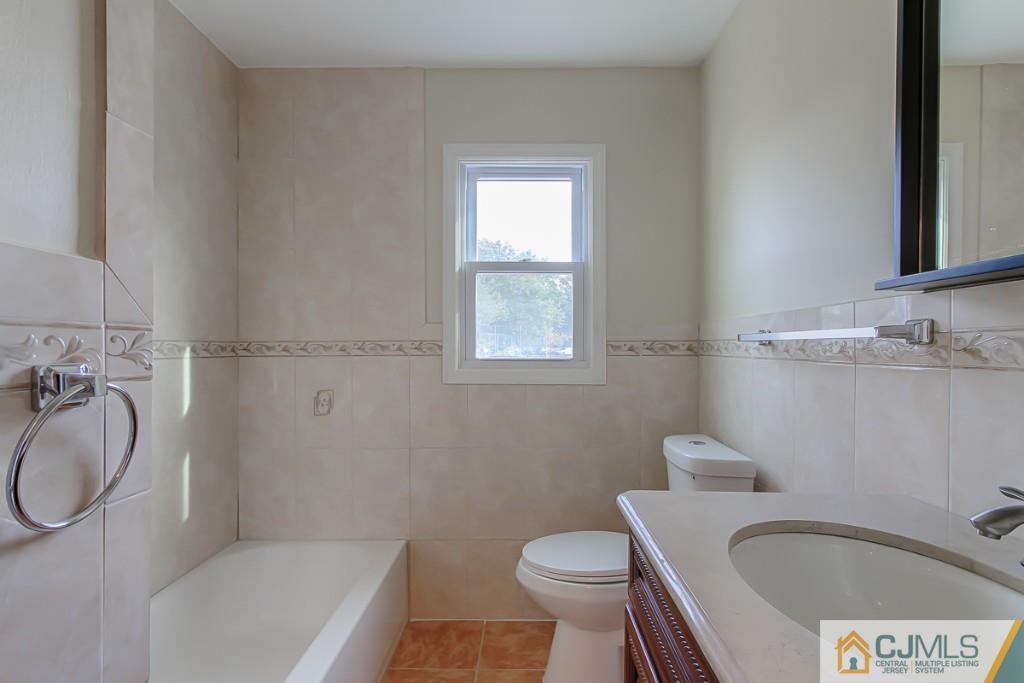31 Longfield Road New Brunswick, NJ 08901 - Photo 8 of 15 a bathroom with a sink toilet a mirror and tub