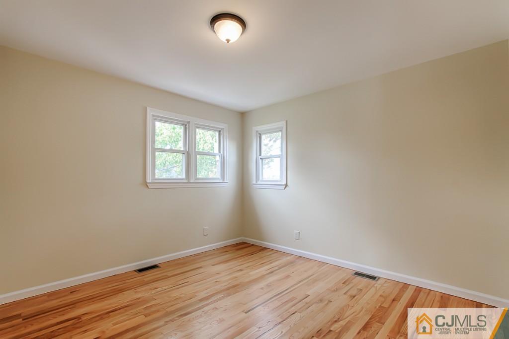 31 Longfield Road New Brunswick, NJ 08901 - Photo 9 of 15 an empty room with wooden floor and windows