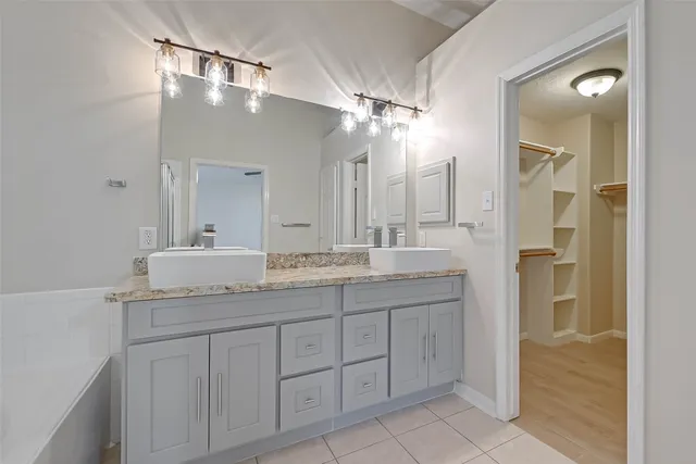 a bathroom with a granite countertop sink a mirror and a shower