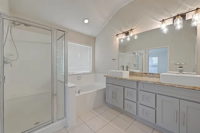 a bathroom with a granite countertop sink a mirror and a bathtub