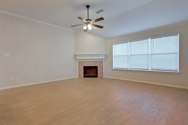 a view of an empty room with a fireplace and a window