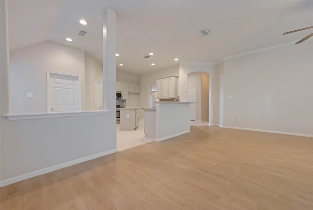 a view of a kitchen with refrigerator and white cabinets