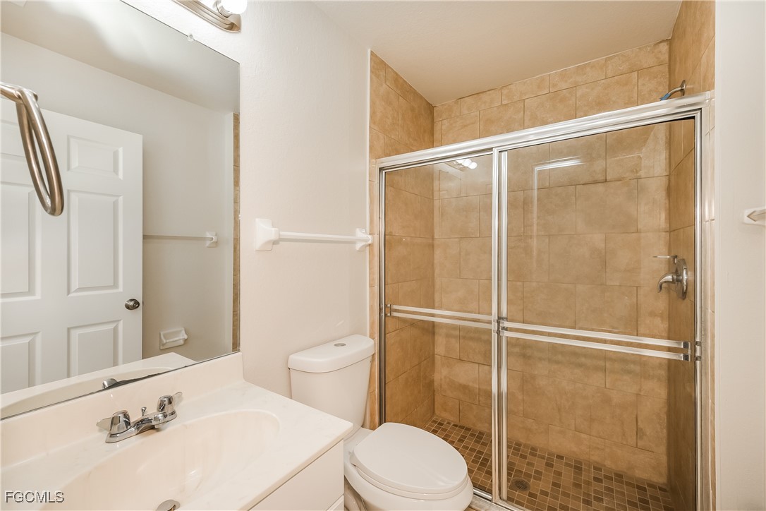 3704 6th Street Southwest Lehigh Acres, FL 33976 - Photo 11 of 16 a white toilet sitting next to a bathroom sink