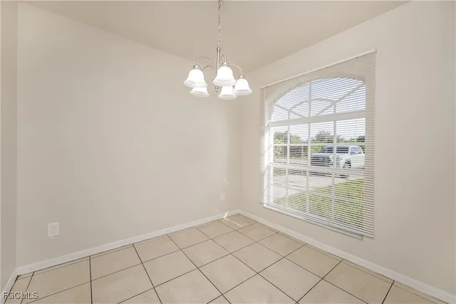 a view of a livingroom with a chandelier fan and windows