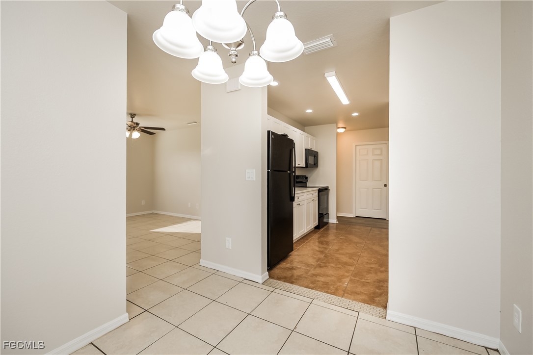 3704 6th Street Southwest Lehigh Acres, FL 33976 - Photo 6 of 16 a view of a hallway with a chandelier