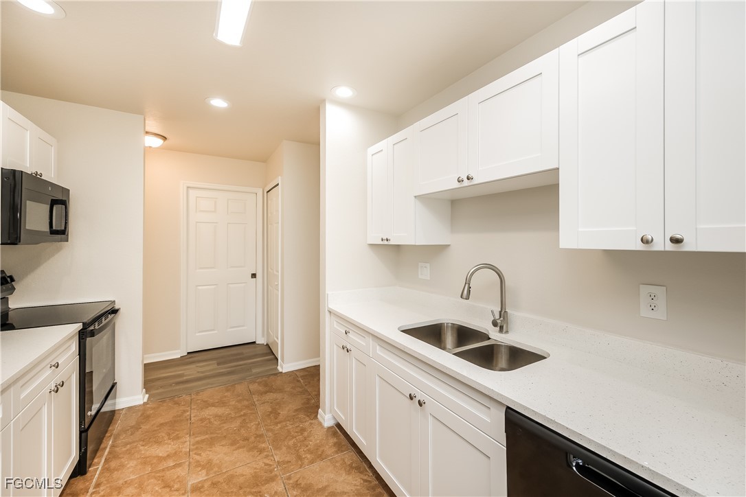 3704 6th Street Southwest Lehigh Acres, FL 33976 - Photo 7 of 16 a kitchen with a sink a refrigerator and cabinets