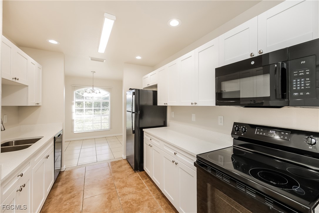 3704 6th Street Southwest Lehigh Acres, FL 33976 - Photo 8 of 16 a kitchen with stainless steel appliances a stove microwave and sink