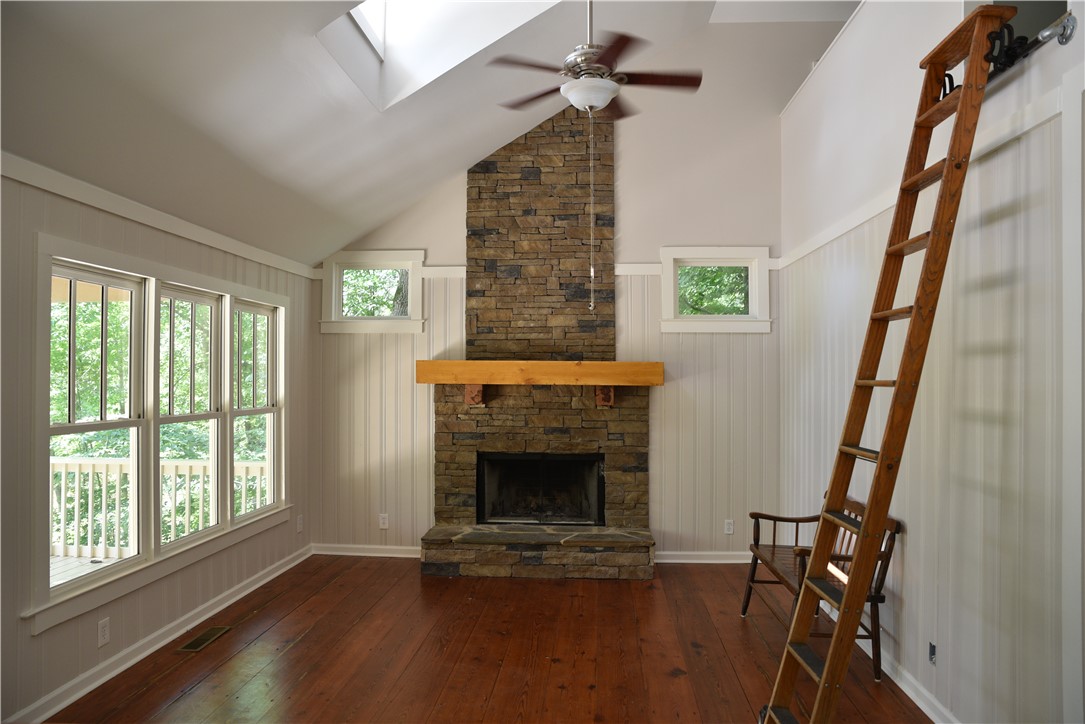 517 Chimney Ridge Westminster, SC 29693 - Photo 7 of 32 A spacious great room showcases a floor-to-ceiling stone fireplace, rich heart pine flooring, and lofty vaulted ceilings with a skylight.