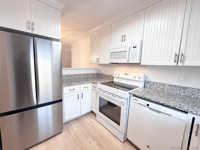 a kitchen with a white cabinets and white stainless steel appliances