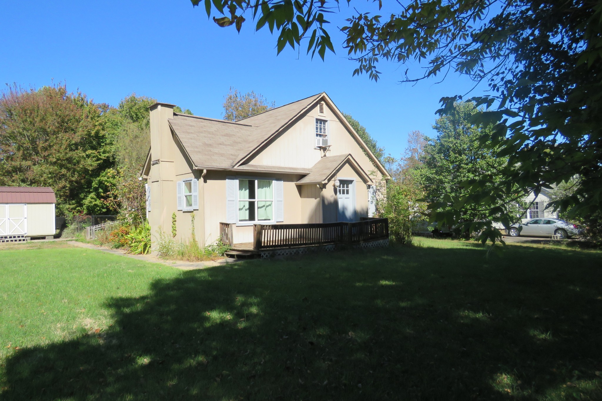 a view of a house with a big yard plants and large trees