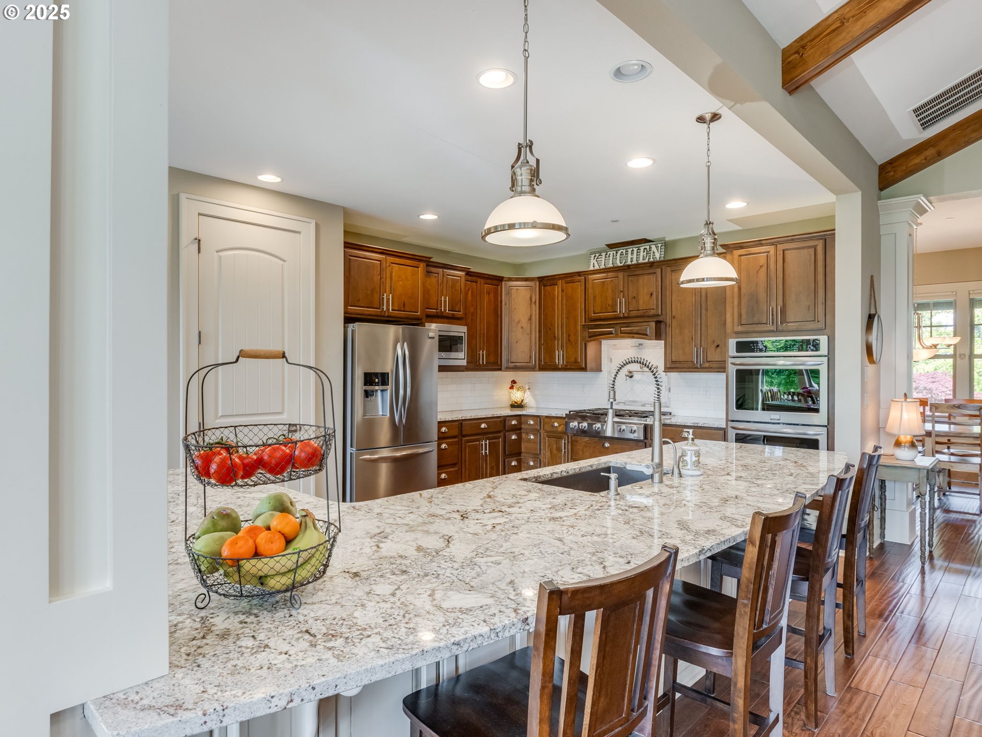 20321 Olmstead Road Northeast Aurora, OR 97002 - Photo 19 of 45 a kitchen with stainless steel appliances granite countertop wooden floor dining table and chairs