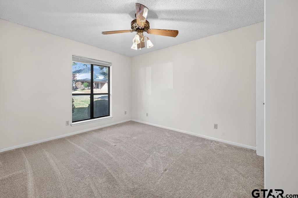 1111 Hillside Drive Athens, TX 75751 - Photo 16 of 20 an empty room with windows and chandelier fan