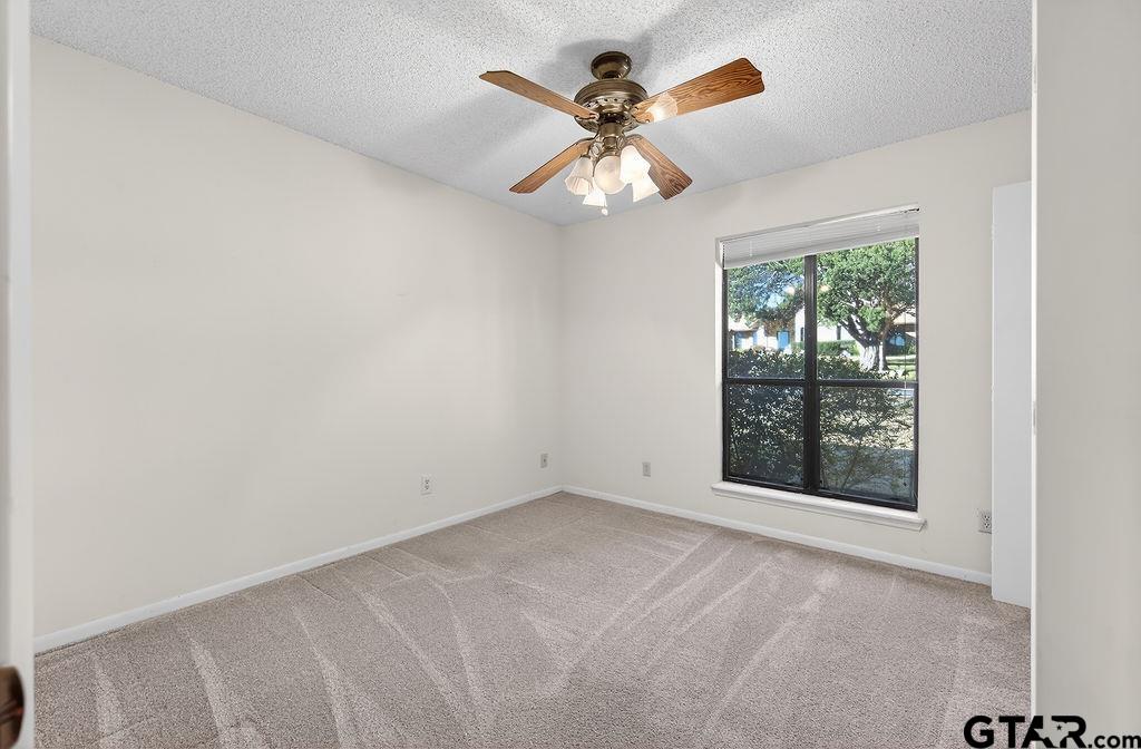 1111 Hillside Drive Athens, TX 75751 - Photo 17 of 20 an empty room with a chandelier fan and windows