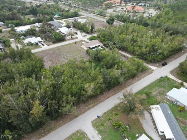 an aerial view of a house with a yard and mountain
