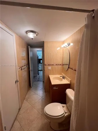 a bathroom with a sink a toilet a mirror and shower