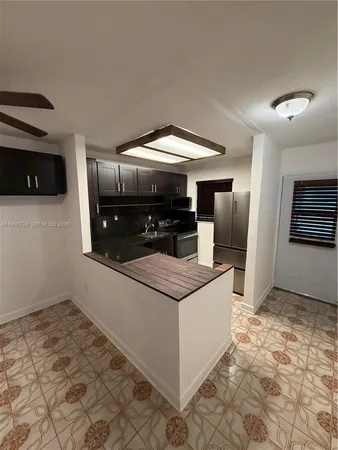 a kitchen with stainless steel appliances granite countertop a refrigerator and a stove
