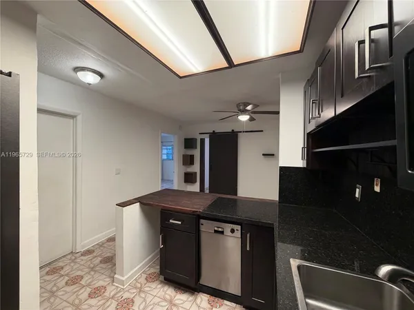 a kitchen with stainless steel appliances granite countertop a sink a stove and a refrigerator