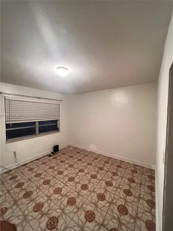 a view of an empty room and kitchen