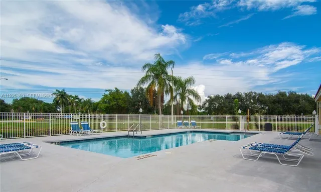 a view of a swimming pool with a lake and trees in the background