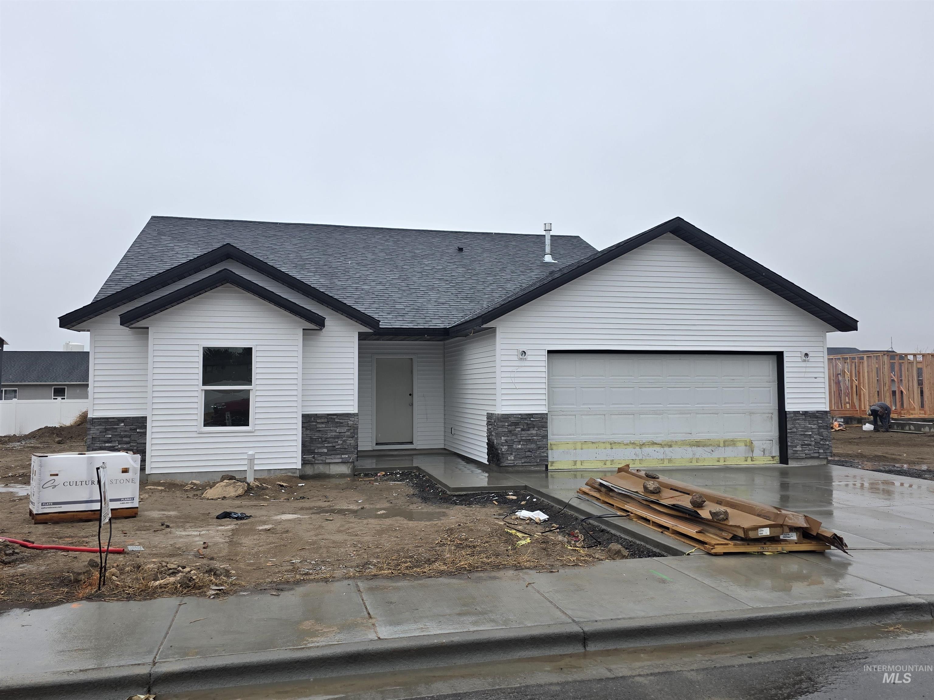 1504 Tverdy Lane Buhl, ID 83316 - Photo 12 of 12 View of front of house with roof with shingles, an attached garage, stone siding, and concrete driveway