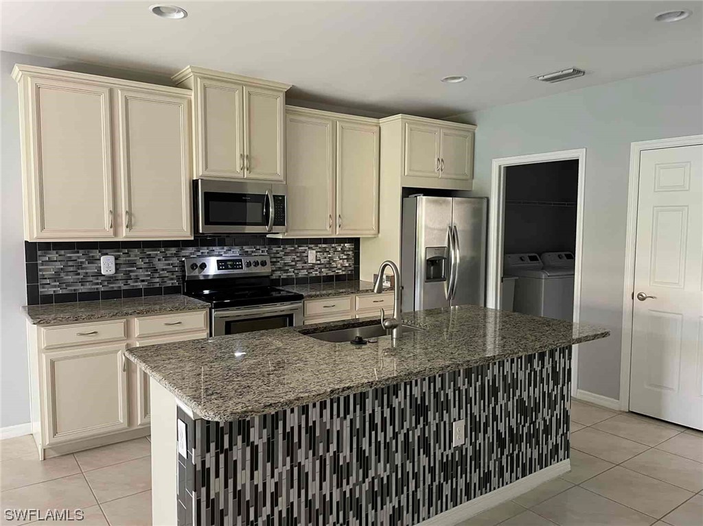 4369 Dutchess Park Road Fort Myers, FL 33916 - Photo 5 of 18 a kitchen with stainless steel appliances granite countertop a stove a sink a microwave a refrigerator and white cabinets