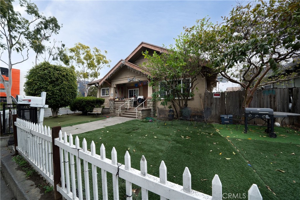 a view of a house with backyard and a tree