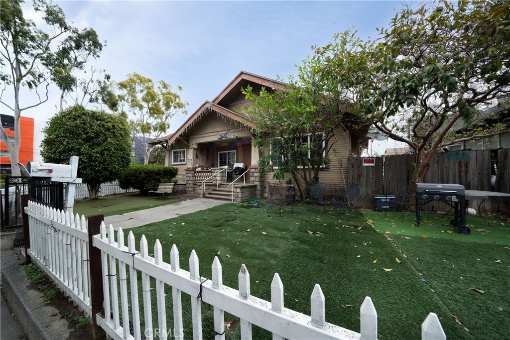 a view of a house with backyard and a tree