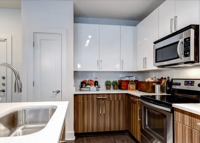 a kitchen with stainless steel appliances granite countertop a sink a stove and cabinets